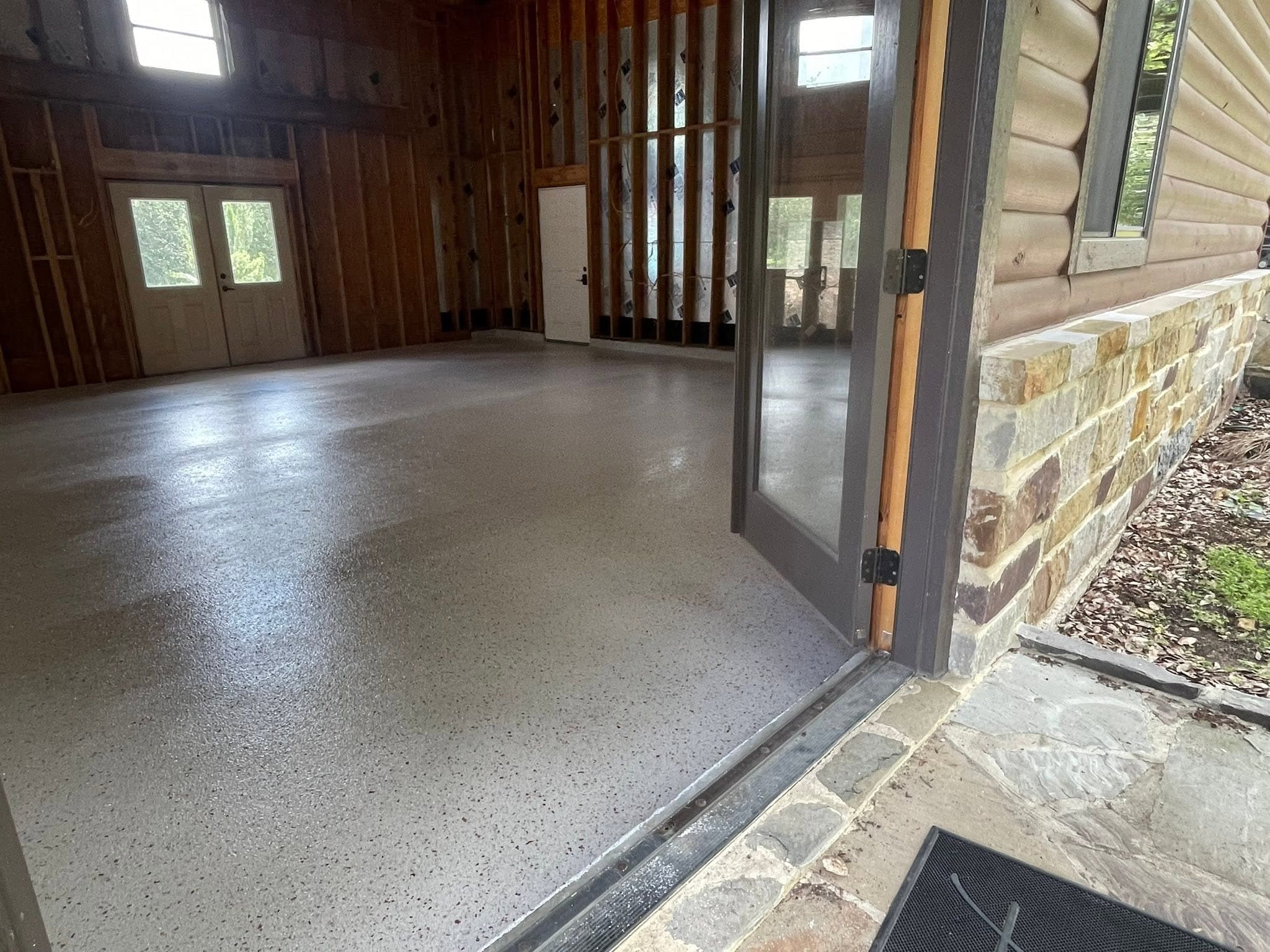 Cypress flake floor in an oversized shop, bay door open to the drive
