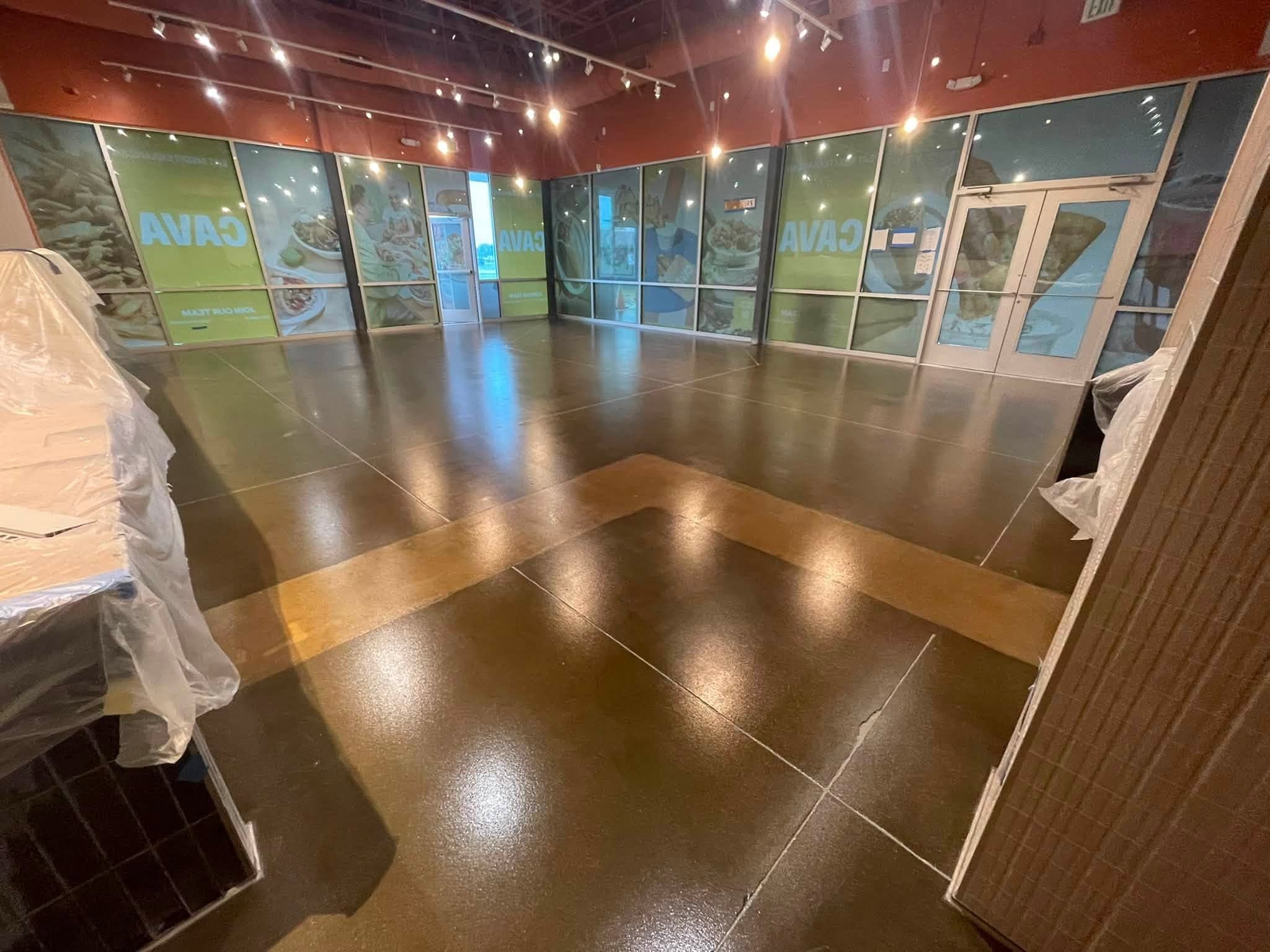 A restaurant dining room after grinding and sealing, glossy under the track lights