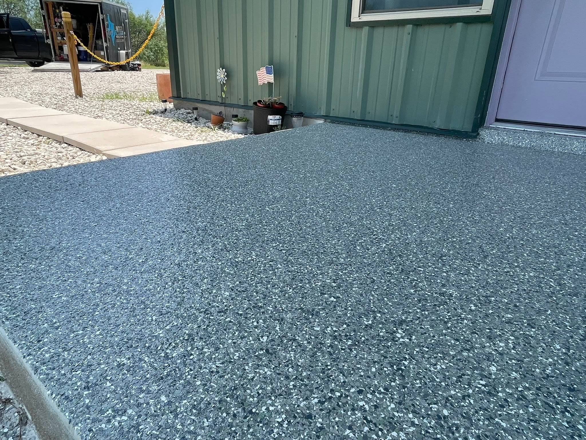 The finished front porch from the walkway, green siding and a gravel bed