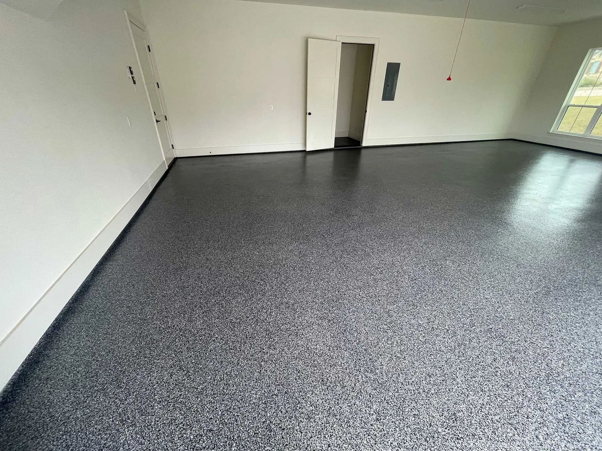 Bright empty two-car garage with a charcoal flake floor