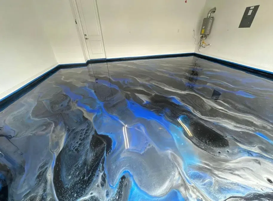 Blue, black, and silver marbled metallic epoxy garage floor with a dark blue border