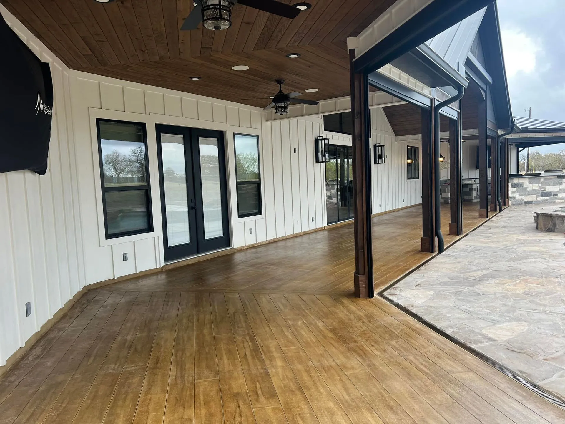 Wood-plank-look stained concrete floor under a covered farmhouse porch