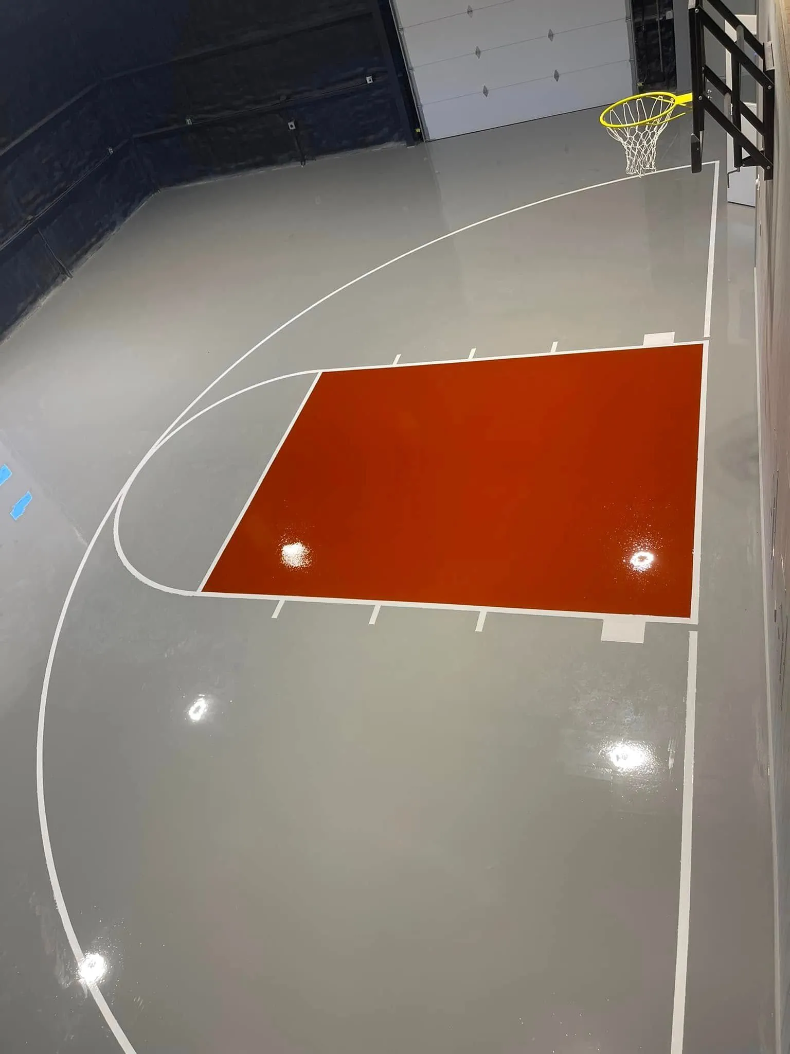 Glossy gray solid epoxy home basketball court with the key finished in red