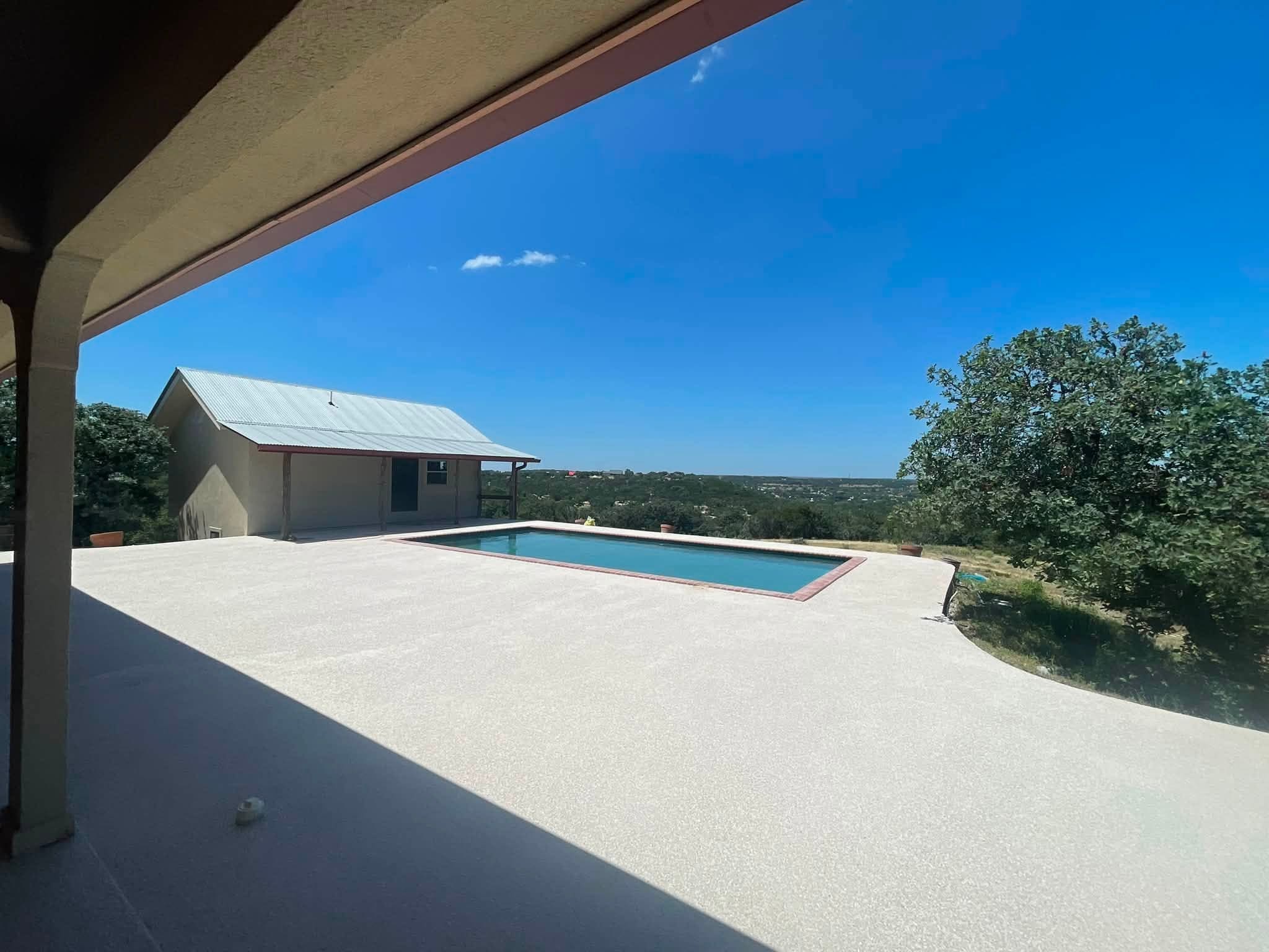 Pool and coated deck on a hilltop, Hill Country running to the horizon